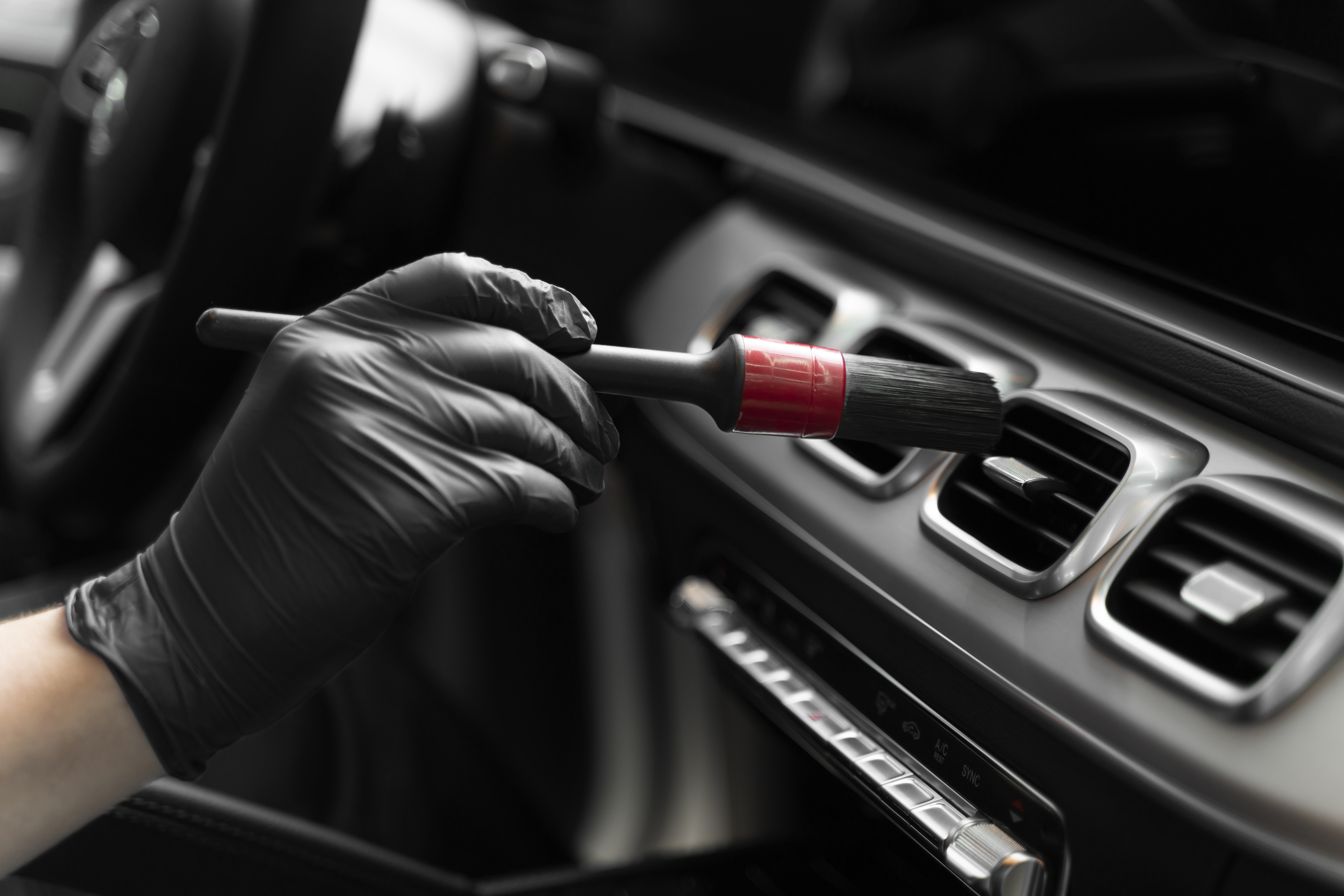 Innenraumaufbereitung – professionelle Reinigung mit Detailing-Pinsel in den Lüftungsschlitzen